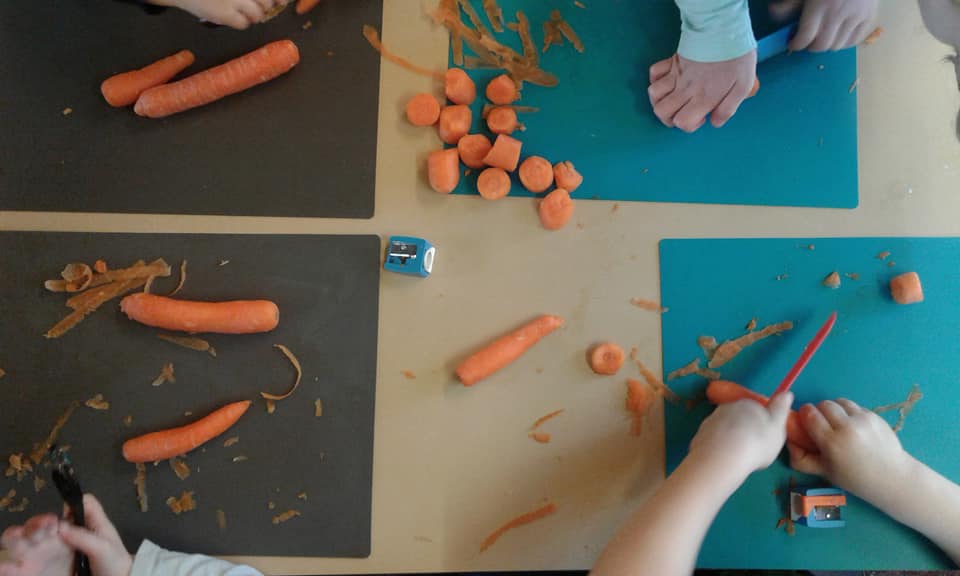 children playing with veg on a table